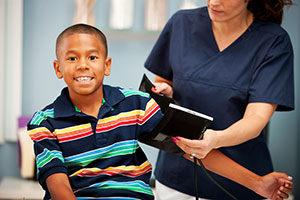 Nurse taking child's blood pressure