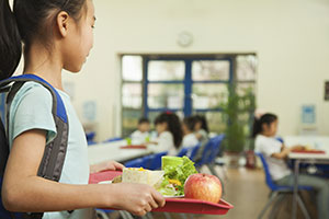 Girl looking for place to sit in cafeteria