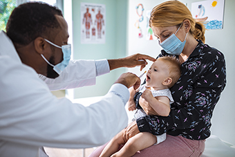 Mom holding baby for flu shot