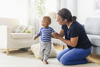 Baby learning how to walk with mom