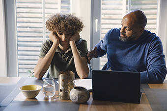 Dad talking with stressed teen son