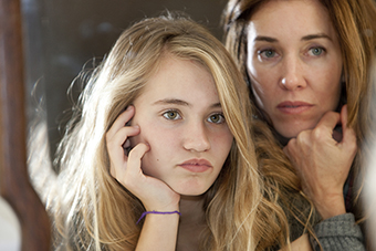 mother and daughter looking into a mirror