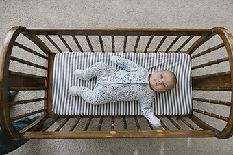 Baby in an old-fashioned wooden crib