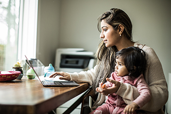 Mom on computer with baby in lap