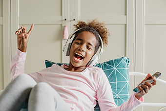 Young girl listening to music on her phone using headphones