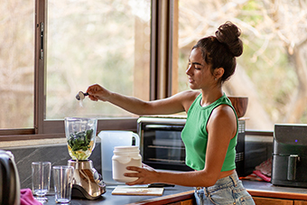Teen girl making a smoothie with protein powder