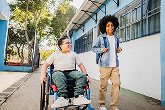 Boy in wheelchair and boy walking on the way to school