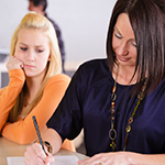 Mother filling out forms for teen