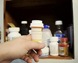 Adolescent reaching for prescription bottle