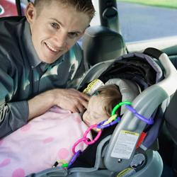 father checking baby's car seat
