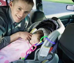 Dad securing baby in car seat