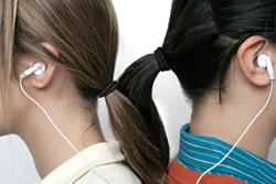Girls sharing earbuds