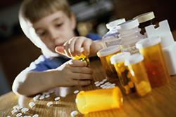 Young boy opening prescription bottles